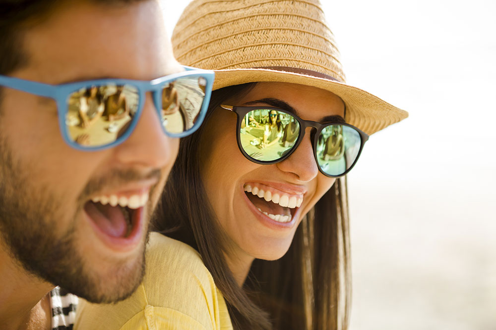 happy couple smiling wearing sunglasses